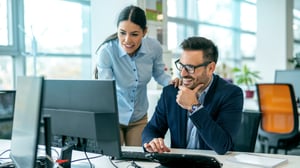 A man and woman looking at a computer to illustrate the importance of an integrated case management system.