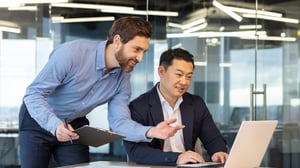 Two fintech employees looking at a project schedule to illustrate fintech onboarding