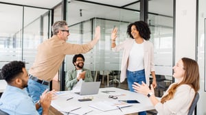 Two colleagues giving high fives to illustrate transformation in the client onboarding process.